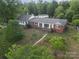 Aerial view of a single-story brick home with a wooden deck and a lush, green yard at 565 Shore Acres Rd, Salisbury, NC 28146
