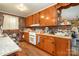 A well-lit kitchen featuring brick walls, wood cabinets, and modern appliances at 565 Shore Acres Rd, Salisbury, NC 28146