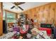 Living room with wood walls, ceiling fan, built in shelves and large window providing natural light at 565 Shore Acres Rd, Salisbury, NC 28146
