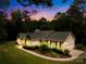 Charming single-story home with a well-manicured lawn, mature trees and a lovely landscaped front yard at twilight at 5903 Wm Griffin Rd, Monroe, NC 28112