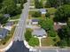 An aerial view showcases the property along a road with lush trees, residential houses and neighborhood streets at 6034 Tuckaseegee Rd, Charlotte, NC 28208