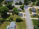 Aerial view shows the property near an intersection, surrounded by lush trees, residential houses and neighborhood streets at 6034 Tuckaseegee Rd, Charlotte, NC 28208