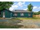 Exterior view of home with a large backyard and green siding and white trim at 6034 Tuckaseegee Rd, Charlotte, NC 28208
