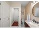 Bathroom showcasing a modern vanity with marble counters, toilet, and round mirror at 6034 Tuckaseegee Rd, Charlotte, NC 28208
