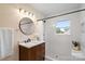 Bathroom featuring a sleek vanity, mirror, black fixtures and white tiled shower at 6034 Tuckaseegee Rd, Charlotte, NC 28208