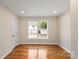 Bedroom featuring hardwood floors and a large window providing lots of natural light at 6034 Tuckaseegee Rd, Charlotte, NC 28208