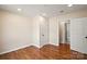 A spacious bedroom with hardwood floors and two doors leading to other rooms at 6034 Tuckaseegee Rd, Charlotte, NC 28208