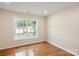 Bedroom showcasing hardwood floors and a window overlooking the yard at 6034 Tuckaseegee Rd, Charlotte, NC 28208