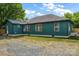 Rear exterior of a green one story house with black trim and white windows under a blue sky at 6034 Tuckaseegee Rd, Charlotte, NC 28208
