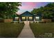 Charming craftsman home with a welcoming porch and lush green lawn at twilight at 6034 Tuckaseegee Rd, Charlotte, NC 28208