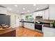 Bright kitchen with stainless steel appliances, white cabinets and hardwood floors at 6034 Tuckaseegee Rd, Charlotte, NC 28208