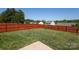 Wide backyard with healthy grass, bordered by a wood privacy fence at 6719 Jerimoth Dr, Charlotte, NC 28215