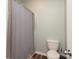 Neutral bathroom features a toilet and a bathtub with a gray shower curtain at 6719 Jerimoth Dr, Charlotte, NC 28215