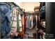 Walk-in closet features built in shelving and clothing rods with an assortment of apparel at 6719 Jerimoth Dr, Charlotte, NC 28215