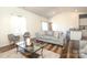 Comfortable living area with a plush gray sofa, hardwood floors, and access to the kitchen area for seamless entertaining at 6719 Jerimoth Dr, Charlotte, NC 28215
