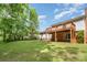 Spacious backyard view showing the house and surrounding trees and lawn at 7106 Marlbrook Dr, Charlotte, NC 28212