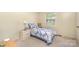 Neutral bedroom with a single bed, white nightstand, and soft carpeting at 7106 Marlbrook Dr, Charlotte, NC 28212