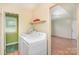 Laundry room with green walls and floor, plus storage shelf above appliances at 7106 Marlbrook Dr, Charlotte, NC 28212