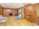 Inviting living room with paneled walls, brick fireplace, and warm, textured carpeting at 7106 Marlbrook Dr, Charlotte, NC 28212