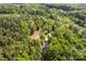 Aerial view of a residence and surrounding trees, with a stream in the background at 743 Dream Ln, Salisbury, NC 28146