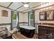 Bright bathroom featuring a clawfoot tub, two windows, vanity, sink, and toilet at 743 Dream Ln, Salisbury, NC 28146
