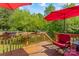 Relax on this wooden deck with red umbrellas and enjoy the outdoor space with comfortable seating and scenic surroundings at 743 Dream Ln, Salisbury, NC 28146