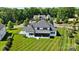 Aerial view of the property featuring a well-manicured lawn, modern home design, and serene wooded surroundings at 1005 Grand Oak Dr, Waxhaw, NC 28173