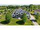 Expansive aerial view of a white brick home with dark roof, large yard, and mature trees at 1005 Grand Oak Dr, Waxhaw, NC 28173