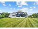 Spacious backyard with striped lawn, showcasing the expansive outdoor living space and architectural design of the home at 1005 Grand Oak Dr, Waxhaw, NC 28173