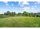 Lush green backyard with well-maintained lawn, mature trees, and landscaping, offering ample space for outdoor activities at 1005 Grand Oak Dr, Waxhaw, NC 28173