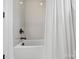 Close up of a bathtub with a white shower curtain and tiled walls, providing a clean and modern look at 1005 Grand Oak Dr, Waxhaw, NC 28173