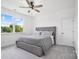 Cozy bedroom with a comfortable gray tufted bed and scenic outdoor views at 1005 Grand Oak Dr, Waxhaw, NC 28173