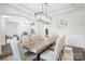 Bright formal dining room features modern light fixture and large dining table with seating for eight at 1005 Grand Oak Dr, Waxhaw, NC 28173