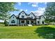 Beautiful two-story white brick home with a welcoming covered front porch and lush green lawn at 1005 Grand Oak Dr, Waxhaw, NC 28173