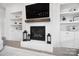 A classic white brick fireplace with wood mantle, built-in shelving and cabinets at 1005 Grand Oak Dr, Waxhaw, NC 28173