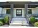 Inviting front porch with white stairs, black railings, and stylish double door entrance at 1005 Grand Oak Dr, Waxhaw, NC 28173