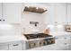 A gourmet kitchen features a high-end gas range, pot filler, stylish vent hood, and quartz countertops at 1005 Grand Oak Dr, Waxhaw, NC 28173