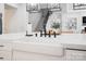 Close-up of a kitchen island with white countertops, a farmhouse sink, and modern fixtures at 1005 Grand Oak Dr, Waxhaw, NC 28173