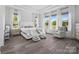 Bright main bedroom featuring tray ceilings, hardwood floors, and three large windows at 1005 Grand Oak Dr, Waxhaw, NC 28173