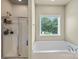 Bright and airy bathroom featuring a separate shower and soaking tub with large window at 1011 Potomac Rd, Indian Trail, NC 28079