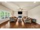 Spacious living room featuring hardwood floors, a ceiling fan, fireplace, and comfortable sofas at 1011 Potomac Rd, Indian Trail, NC 28079