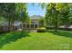 Landscaped backyard featuring a screened porch, brick patio, and well-maintained lawn perfect for outdoor entertaining at 1012 Sudbury Ln, Matthews, NC 28104