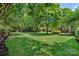 Expansive backyard with lush green lawn, mature trees and landscaping creating a serene outdoor space at 1012 Sudbury Ln, Matthews, NC 28104