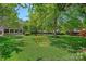 Large backyard featuring green grass, mature trees, and play equipment at 1012 Sudbury Ln, Matthews, NC 28104