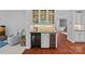 Stylish bar area with wine refrigerators, stone backsplash, and glass shelving at 1012 Sudbury Ln, Matthews, NC 28104