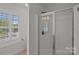 Bathroom showcasing a glass shower with a silver frame and a white plantation shuttered window at 1012 Sudbury Ln, Matthews, NC 28104