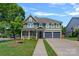 Charming two-story home featuring a covered front porch, attached two-car garage, and well-manicured lawn at 1012 Sudbury Ln, Matthews, NC 28104