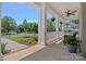 Relaxing front porch featuring a ceiling fan, hanging plants and a seating area at 1012 Sudbury Ln, Matthews, NC 28104