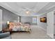 Spacious main bedroom featuring tray ceilings, plush carpet, a decorative ceiling fan, and large windows at 1012 Sudbury Ln, Matthews, NC 28104
