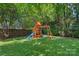 Backyard featuring green grass and a playground with a slide and swings at 1012 Sudbury Ln, Matthews, NC 28104